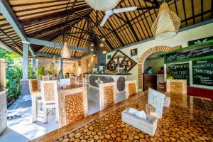 a restaurant with a bar with chairs and a menu at Kelapa Cottage in Amed
