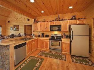 cocina grande con armarios de madera y nevera en Majestic Springs Lodge Cabin, en McCookville 28 fotos más