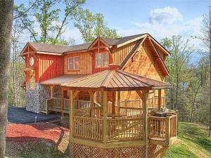 Casa de madera grande con cenador grande en Majestic Springs Lodge Cabin, en McCookville