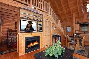 Una sala de estar con chimenea y televisión. en Kiss Me Goodnight Cabin, en McCookville