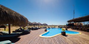 a swimming pool with chaise lounges and chairs on a beach at CAP KIMONY in Morondava