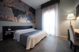 a bedroom with a large bed and a window at Hotel Master in Albignasego