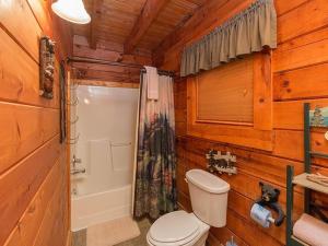 a wooden bathroom with a toilet and a shower at Forest Fling Cabin in McCookville