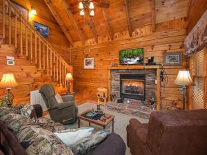 a living room with a fireplace in a log cabin at Forest Fling Cabin in McCookville