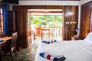 a bedroom with two beds and a desk and a table at Rainbow Bay Beach & Dive Resort in Siquijor