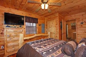 um quarto com uma cama e uma televisão de ecrã plano em Secluded Memories Cabin em McCookville