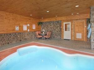 a swimming pool in a room with a table and chairs at Majestic Springs Lodge Cabin in McCookville