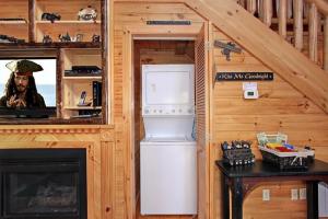 una cocina con nevera en una casa pequeña en Kiss Me Goodnight Cabin, en McCookville