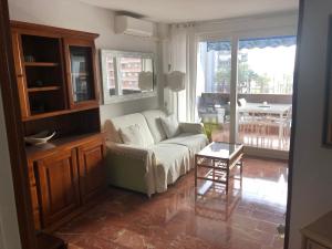 salon z kanapą i stołem w obiekcie Apartamento frente al mar (Avda costa Blanca) w Alicante