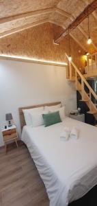Un dormitorio con una gran cama blanca y una escalera en Quinta d'Areda Wine&Pool Experience, en Fafe