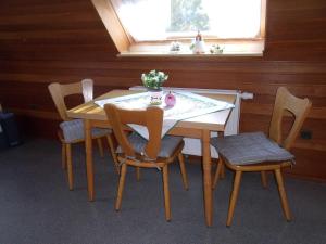 a table and chairs in a room with a window at Ferienwohnung Lehmann 15090 in Leer +6 photos