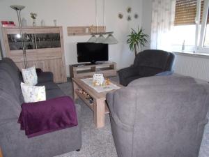 a living room with two chairs and a television at Ferienwohnung Lehmann 15090 in Leer