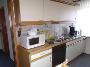 a kitchen with a microwave oven and a sink at Ferienwohnung Lehmann 15090 in Leer