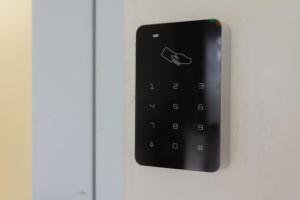 a black remote control on a white door at OYO 387 Alfa Guest House in Jakarta