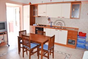 Maridea - Fragolino في بونسا: مطبخ مع طاولة وكراسي خشبية ومغسلة