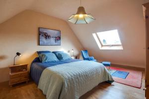 濱海莫厄朗的住宿－Ti Cairn，一间卧室配有一张带蓝色棉被的床