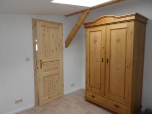 um quarto com um armário de madeira e uma porta em Alte Malztenne im Herzen der Schorfheide em Golzow