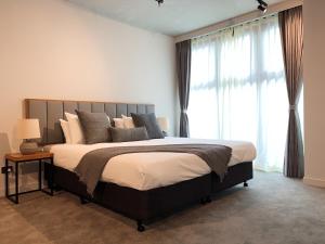 a bedroom with a large bed and a large window at City Edge South Melbourne Apartment Hotel in Melbourne