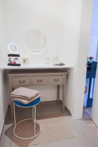 a bathroom with a vanity with a mirror and a stool at Appartements Villa Schwanenteich in Fehmarn