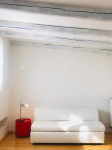salon z białą kanapą i czerwonym stołem w obiekcie Legrenzi Rooms w Mestre