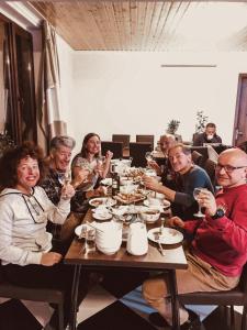 Un groupe de personnes assises autour d'une table à manger dans l'établissement Hotel panorama svaneti, à Mestia
