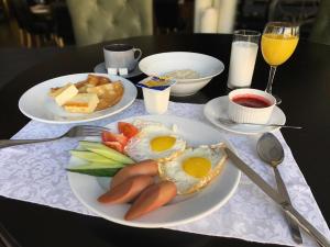 a table with two plates of breakfast food on it at Belogorye Hotel in Belgorod