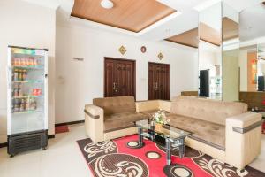 a living room with a couch and a table at RedDoorz Syariah @ Jalan Simpang Gajayana in Malang