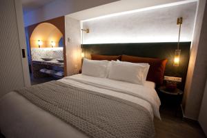 Un dormitorio con una cama grande con almohadas blancas. en Noufara, en Pireo