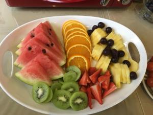 a white plate of fruit on a table at The Quies in Newquay