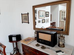 a microwave sitting on top of a dresser with a mirror at En Patmo Holiday Home in Patmos