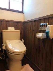 佐賀市にある一棟貸切の宿　三調家の木製の壁の客室内にトイレ付きのバスルームがあります。