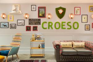 a living room with a couch and a sign on the wall at Hotel Indigo - Cardiff by IHG in Cardiff