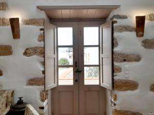a door in a room with a stone wall at En Patmo Holiday Home in Patmos