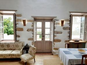 a room with a bed and a couch and windows at En Patmo Holiday Home in Patmos