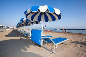 a group of beach chairs and umbrellas on the beach at Residence Margherita in Cattolica