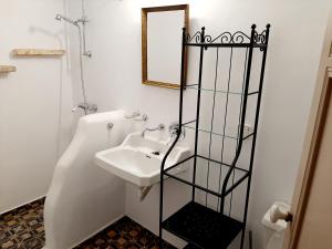 a white bathroom with a sink and a mirror at En Patmo Holiday Home in Patmos