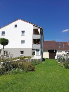 a white house with a green yard at fewoflagmeier Meidelstetten I Maisonetten Wohnung Alb in Hohenstein