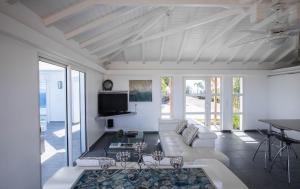 a living room with a couch and a tv at Dream Villa St-Jean 602 in Saint Barthelemy
