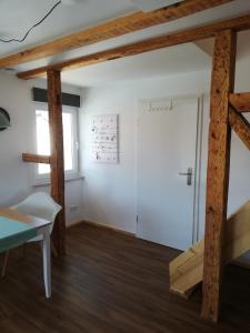 a room with a door and wooden beams at fewoflagmeier Meidelstetten I Maisonetten Wohnung Alb in Hohenstein