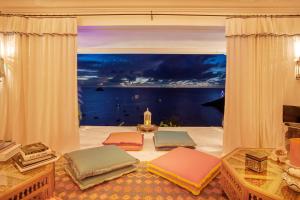 Habitación con almohadas en el suelo y ventana grande. en Dream Villa Corossol 816, en Gustavia