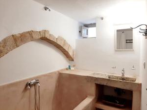 bagno con lavandino e arco alle pareti di En Patmo Holiday Home a Patmo (Patmos)