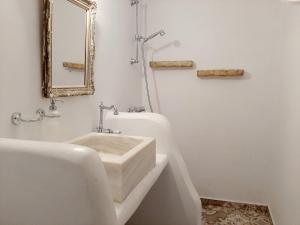 a white bathroom with a sink and a mirror at En Patmo Holiday Home in Patmos