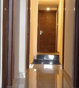 pasillo de un edificio con puerta y espejo en EMPIRE INN HOTEL en Chennai