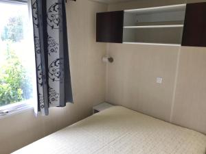 a small bedroom with a bed and a window at Camping Castell D'aro in Platja d'Aro