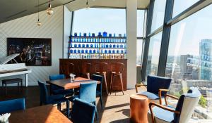 a restaurant with a piano and tables and chairs at The Cube Hotel Birmingham in Birmingham