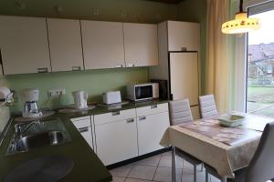 a kitchen with white cabinets and a table with a microwave at Ferienwohnung Wildung in Lüneburg