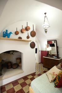 a living room with a fireplace with pots and pans on the wall at La Casa nel Vico in Marittima