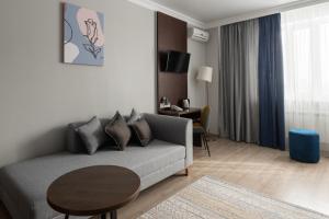 a living room with a couch and a table at NCityHotel in Astana