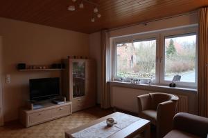 uma sala de estar com uma televisão e uma janela em Ferienwohnung Wildung em Lüneburg