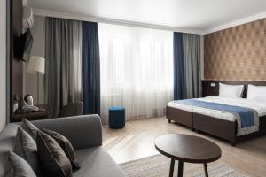 een hotelkamer met een bed en een bank bij NCityHotel in Astana
